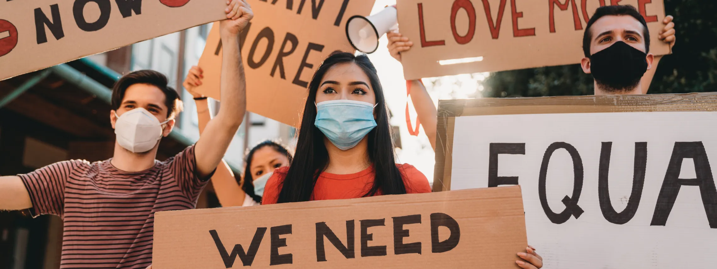 People holding up signs that say we need change and equality